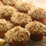 Banana muffins with crumb topping on reclaimed wood boards.