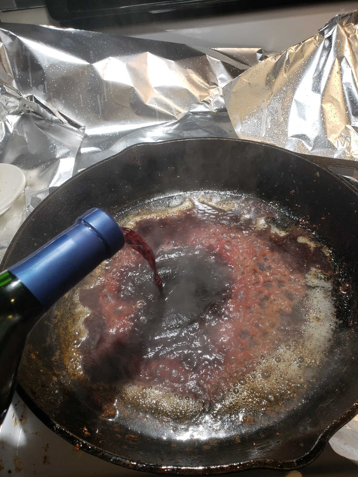 Deglazing cast iron skillet with red wine.