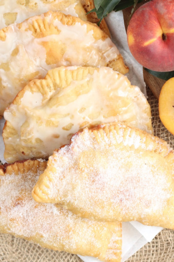 Hand pies on burlap, fresh peaches around.