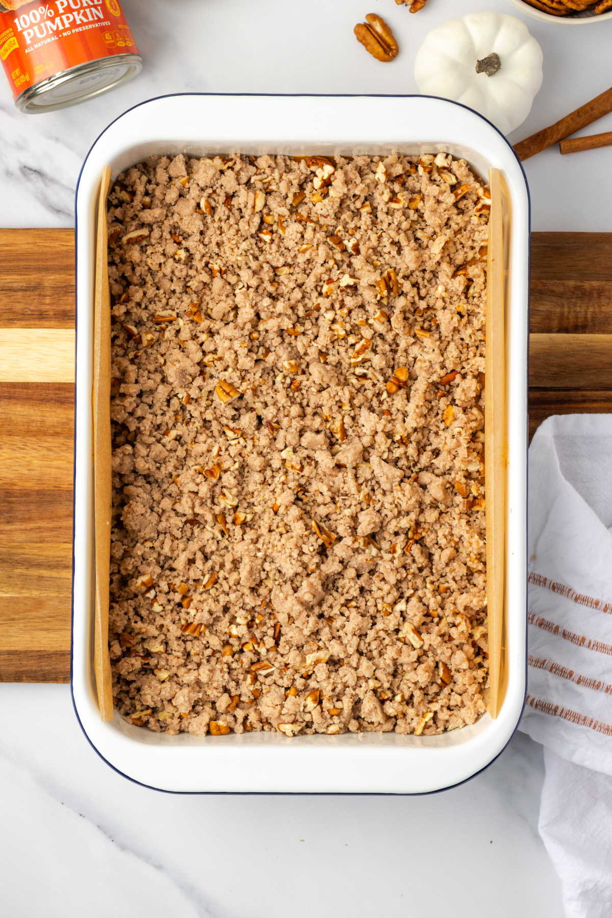Unbaked crumb cake in white baking pan.