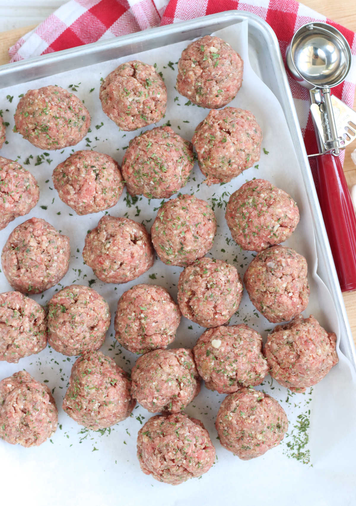 Uncooked meatballs on sheet pan.