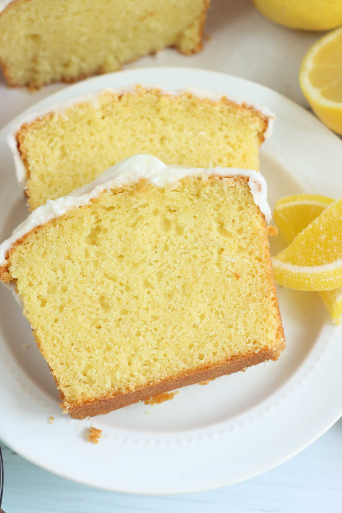 Slices of lemon cake with icing on small white plate.