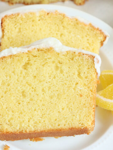 Two slices of lemon loaf cake on small white plate.