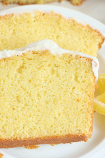 Two slices of lemon loaf cake on small white plate.