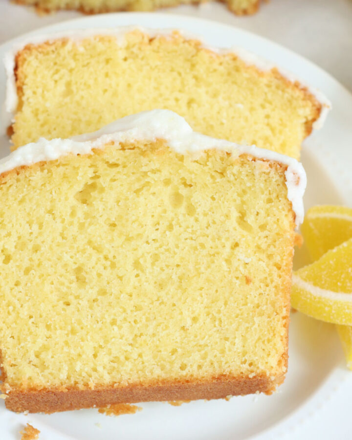 Two slices of lemon loaf cake on small white plate.