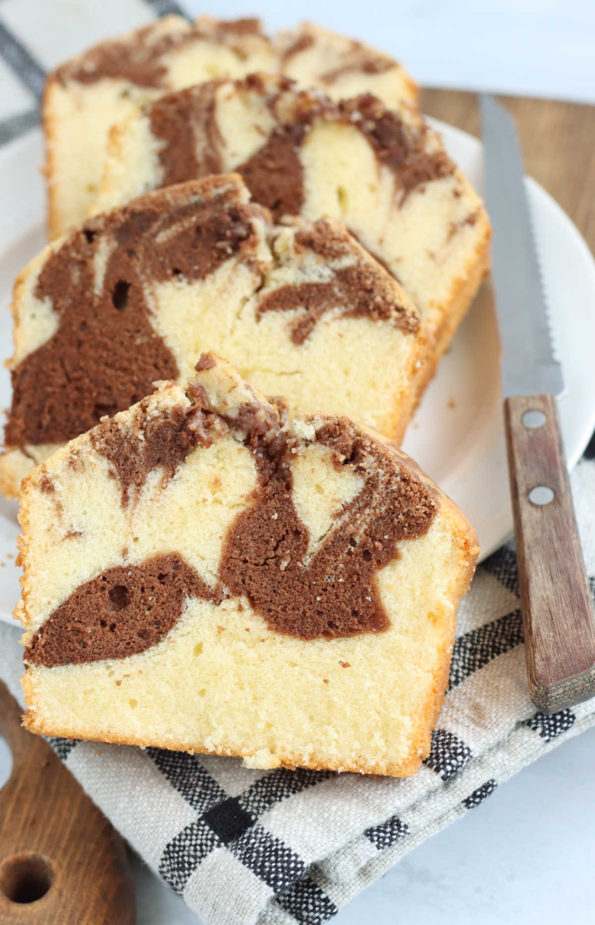 Slices of marble pound cake on small white plate.
