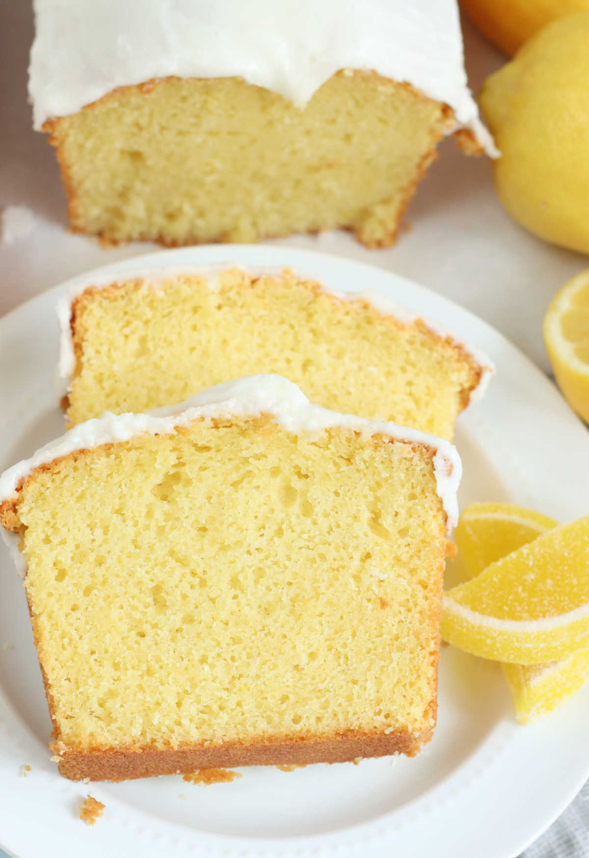 Close up of lemon loaf cake slices on small white plate.