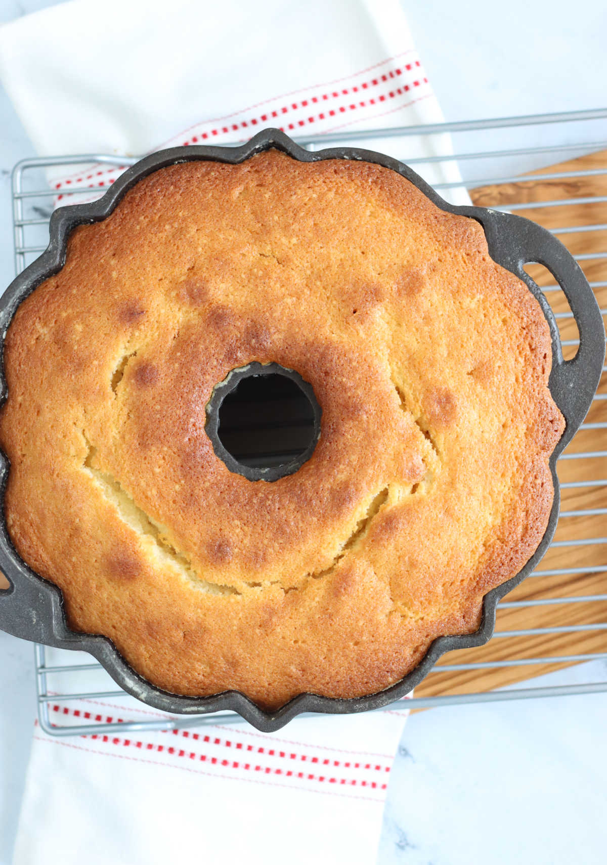Cast iron fluted cake pan on metal cooling rack.