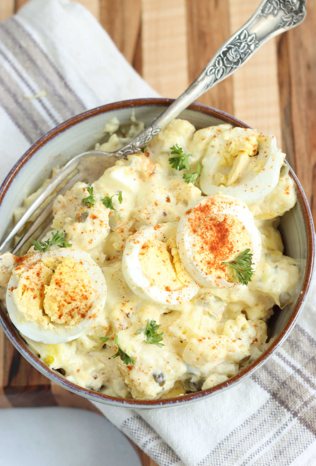 Potato salad with hard boiled eggs in small bowl with fork.