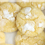 Close up of lemon cookies with powdered sugar on sheet pan.