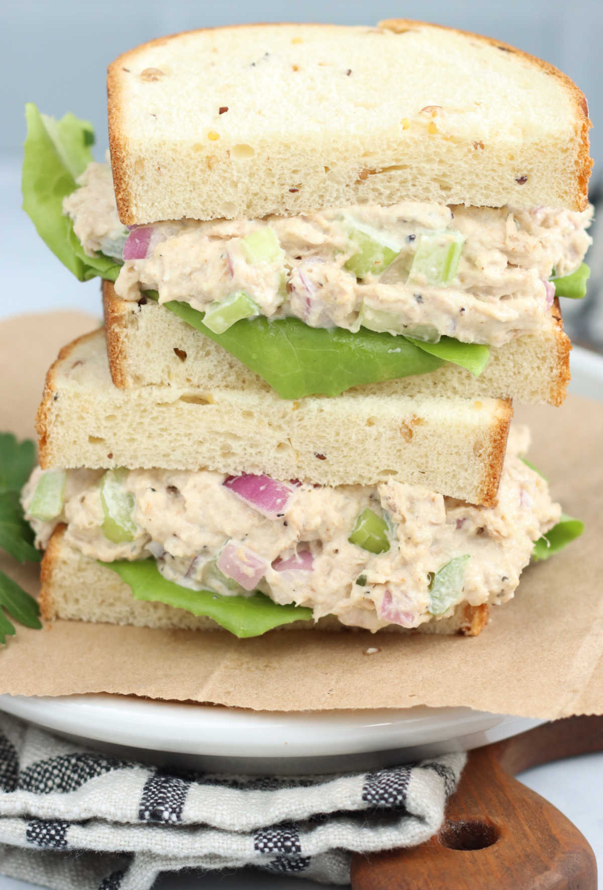 Tuna sandwich stacked on top of each other on brown Kraft paper.