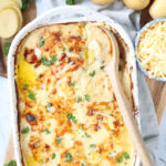 Scalloped potatoes baked in white baking dish.