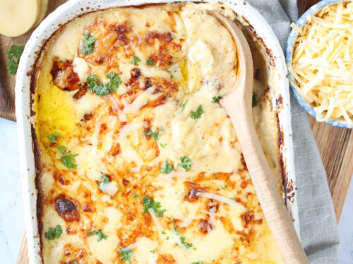 Scalloped potatoes baked in white baking dish.