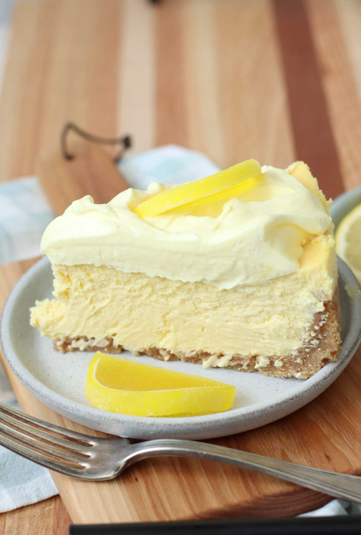 Slice of lemon cheesecake on small plate with Boston fruit slice candies.