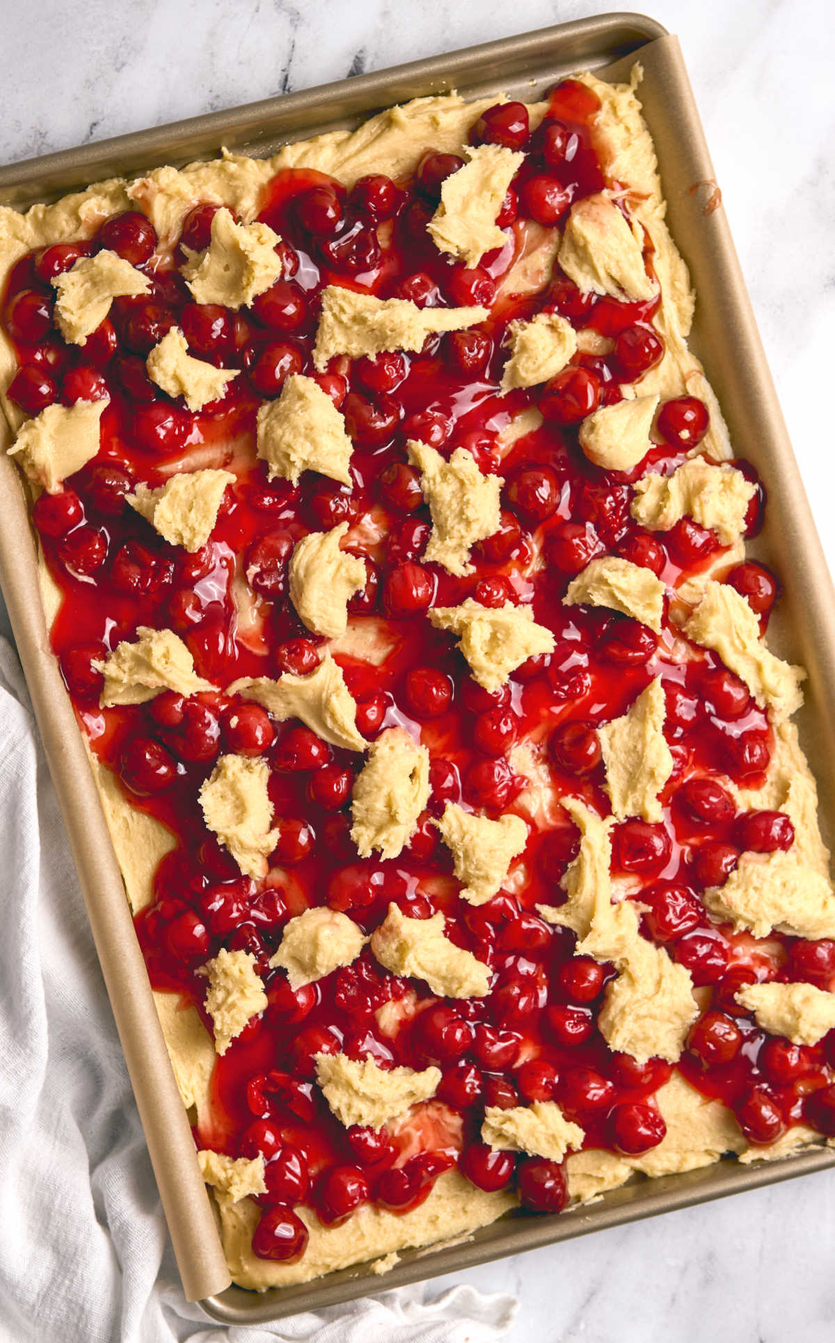 Sheet pan with unbaked cherry bars.