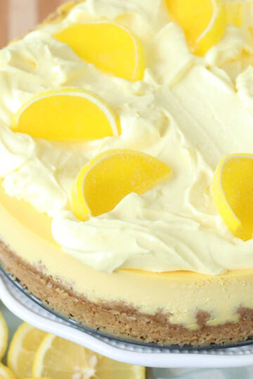 Closeup of lemon cheesecake on footed cake dish.