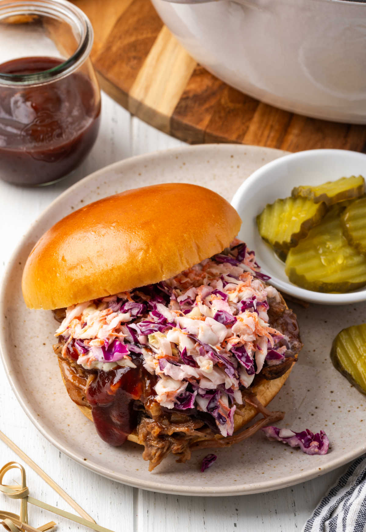 BBQ pulled pork on brioche bun with coleslaw and pickles.
