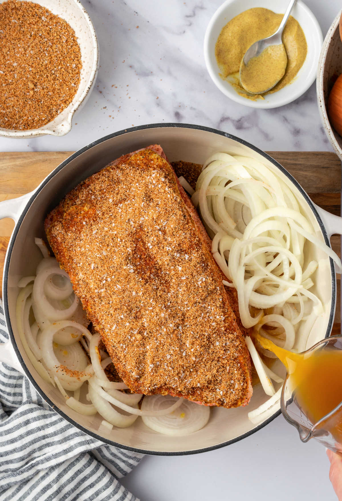 Pork shoulder with dry rub and onions in Dutch oven.