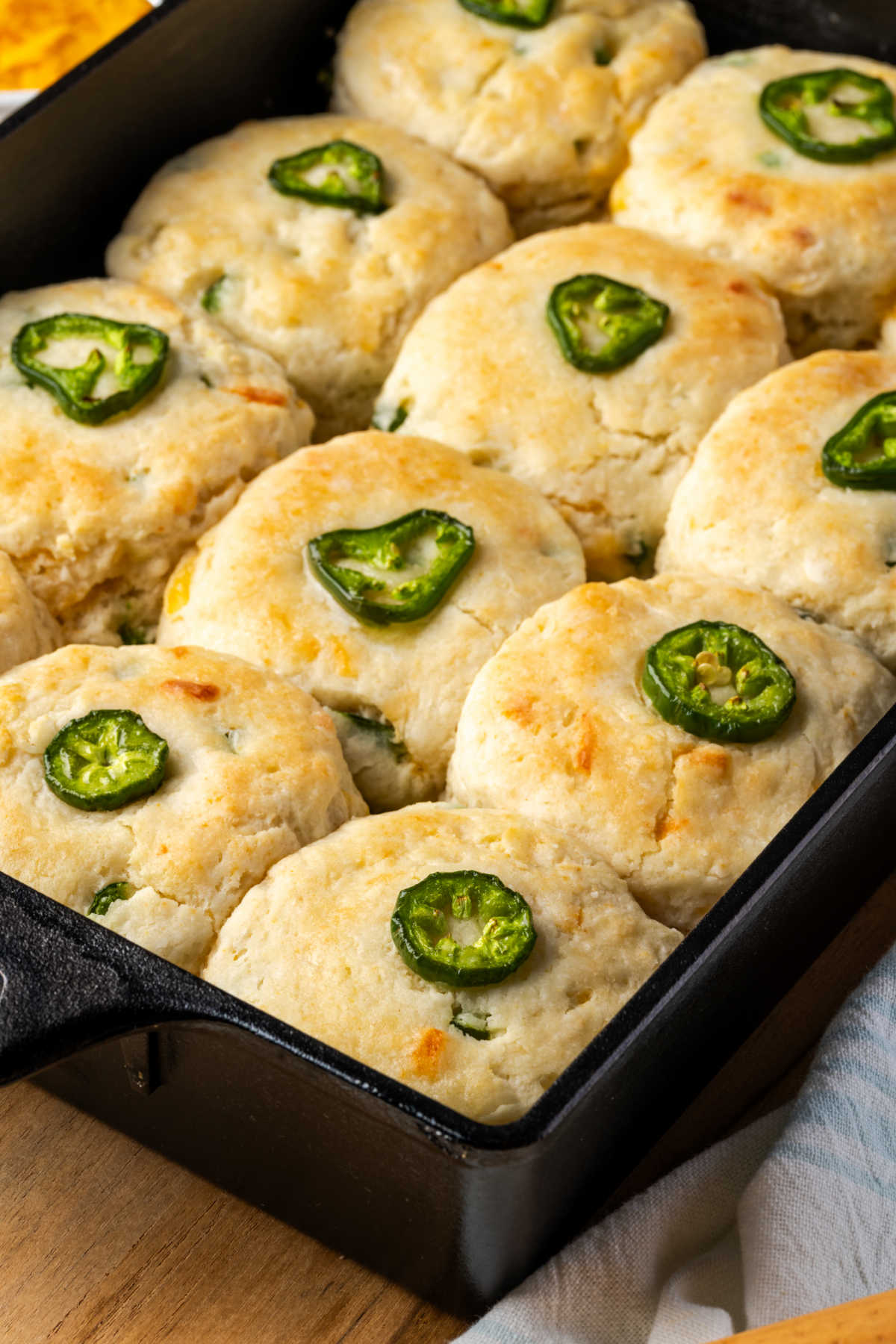 Biscuits with jalapenos and cheddar in cast iron baking pan.