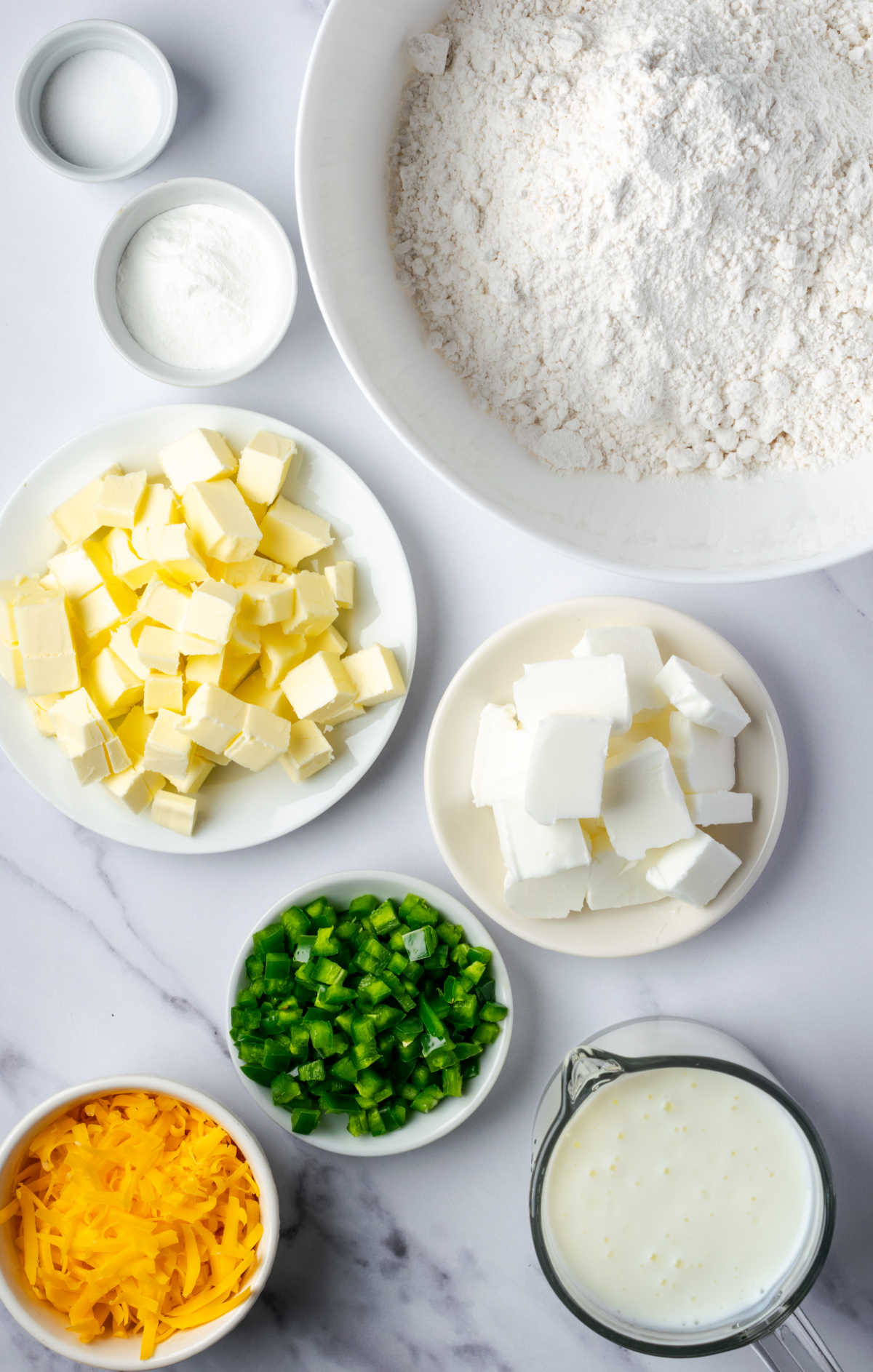 Ingredients in white bowls for biscuits.