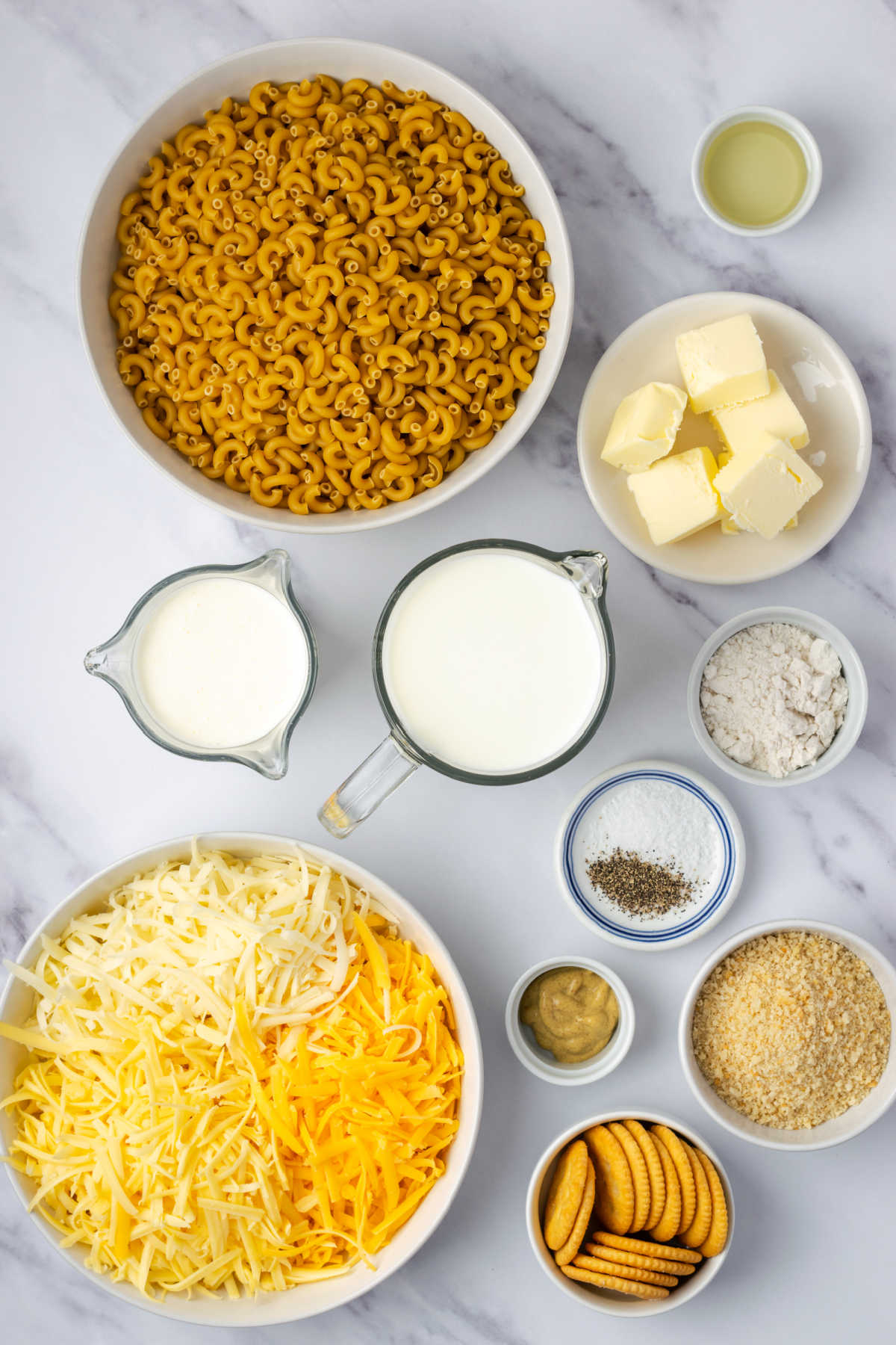 Ingredients in small white bowls for mac and cheese.