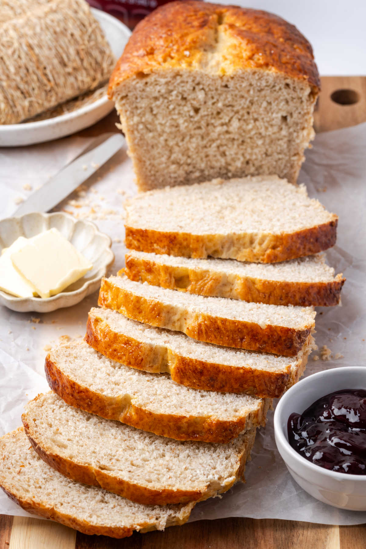 Shredded wheat bread partially sliced on cutting board.