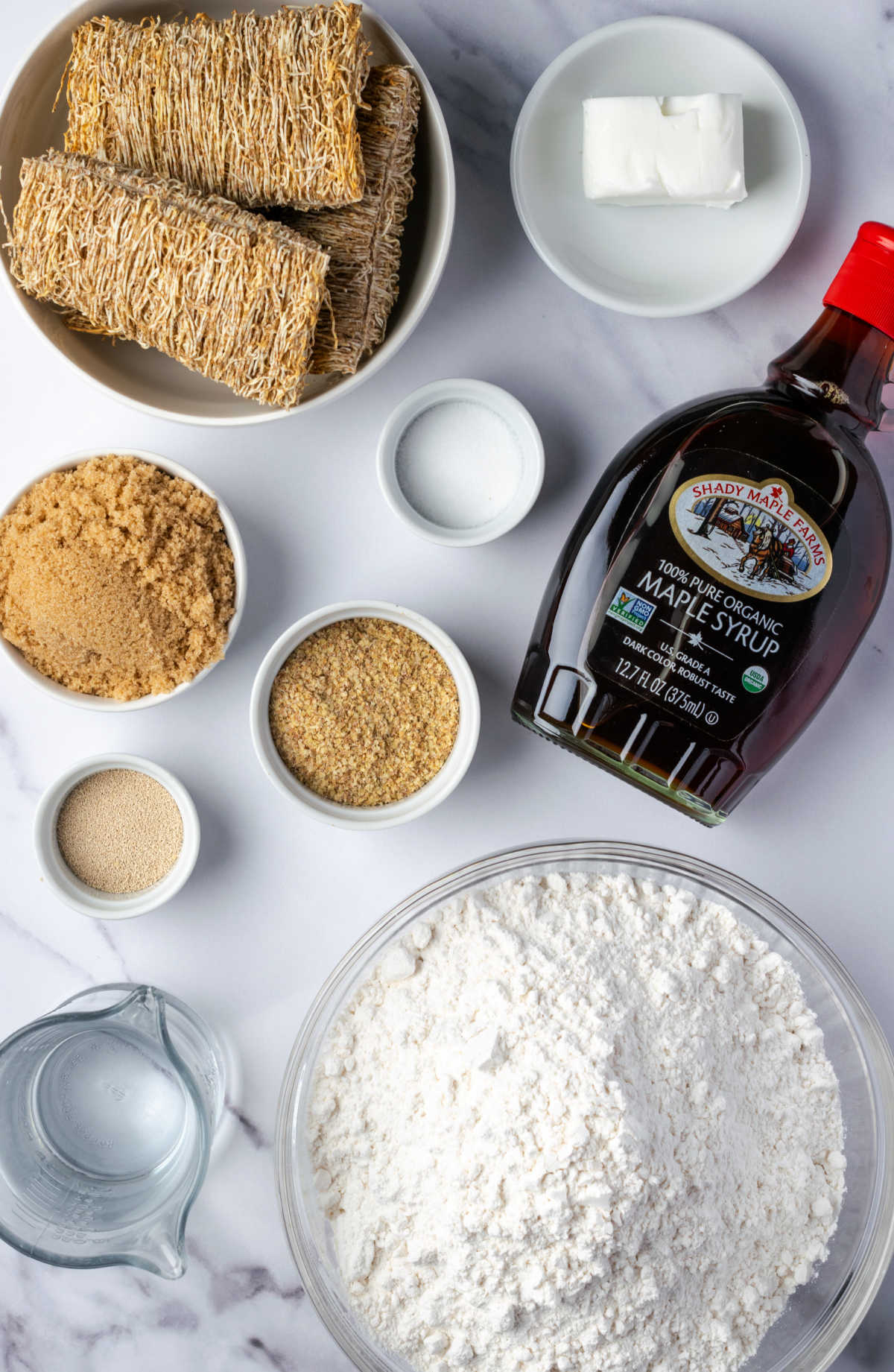 Ingredients for shredded wheat bread on white marble.