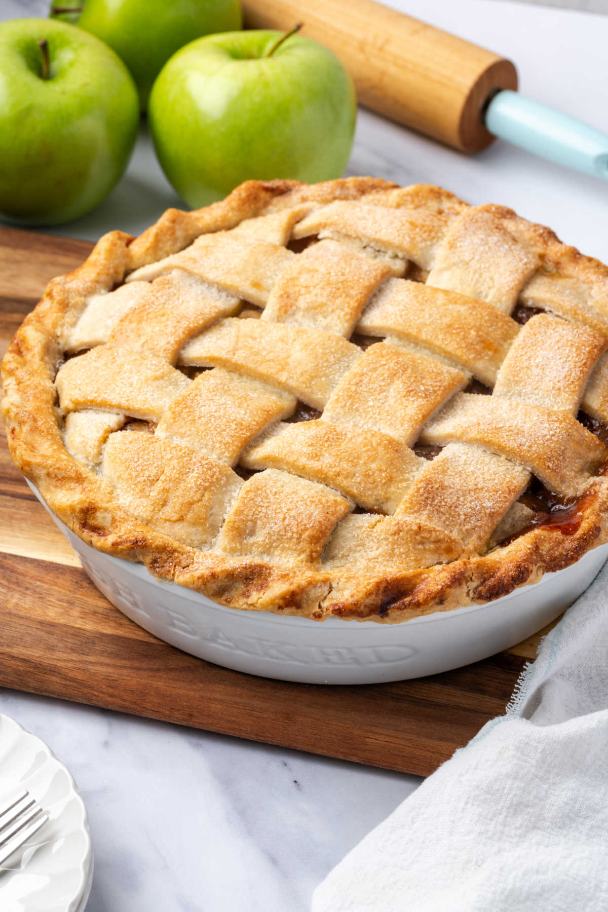 Baked pie with lattice crust in white pie dish.