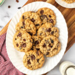 Oatmeal raisin cookies on small white plate.