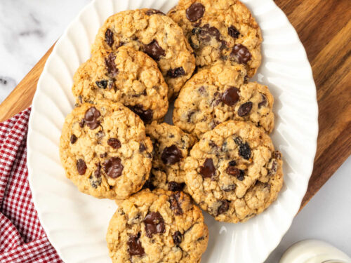 Oatmeal raisin cookies on small white plate.