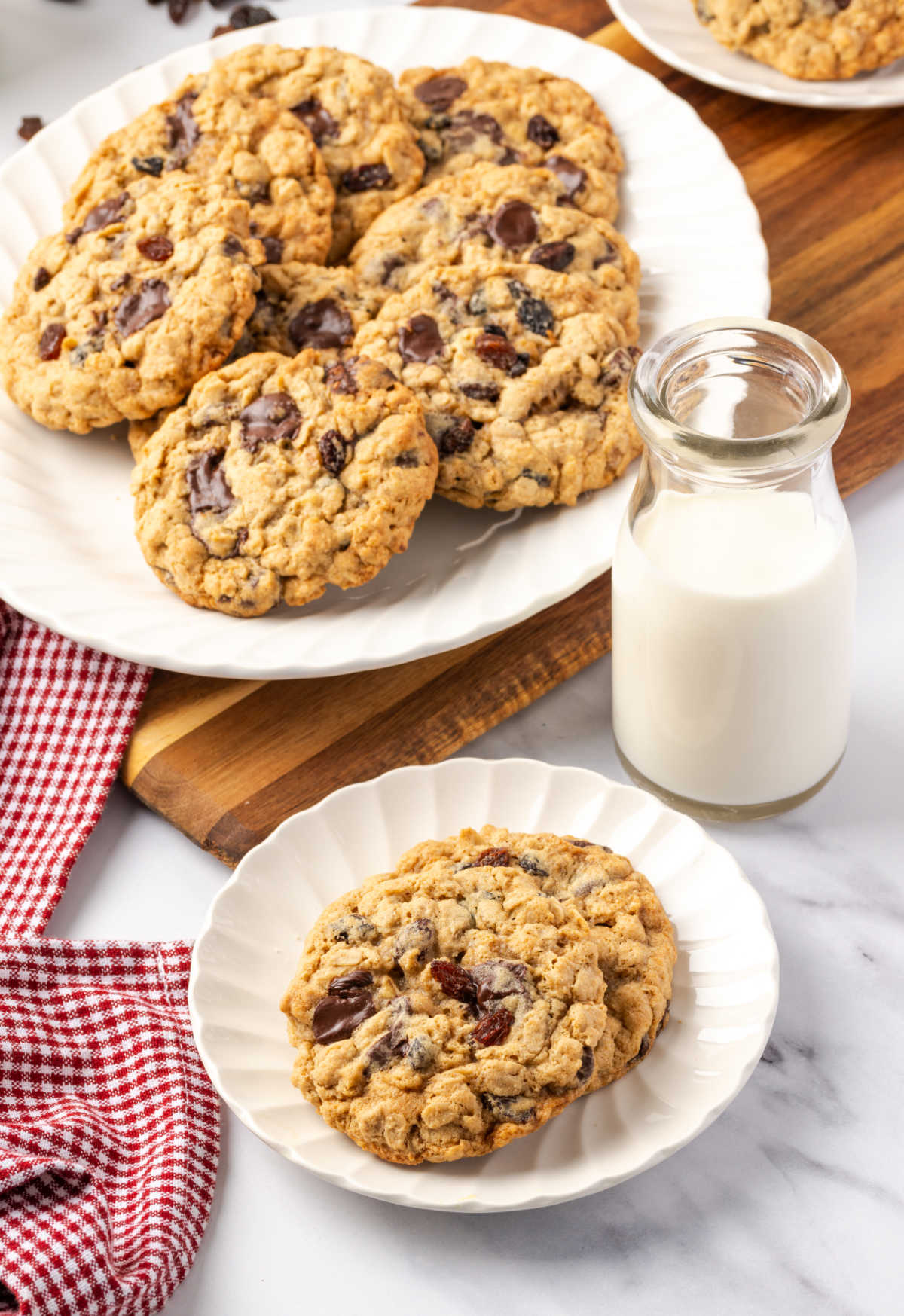 Cookies on small white plate, milk to side in glass jar.