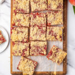 Peach bars cut up on wood cutting board.