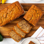 Sliced zucchini bread on wood cutting board.