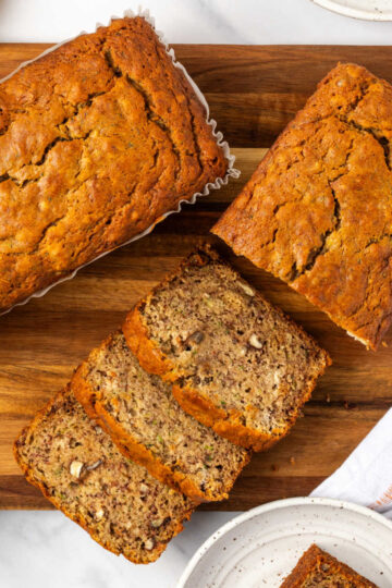 Sliced zucchini bread on wood cutting board.