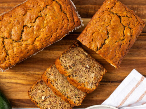 Sliced zucchini bread on wood cutting board.
