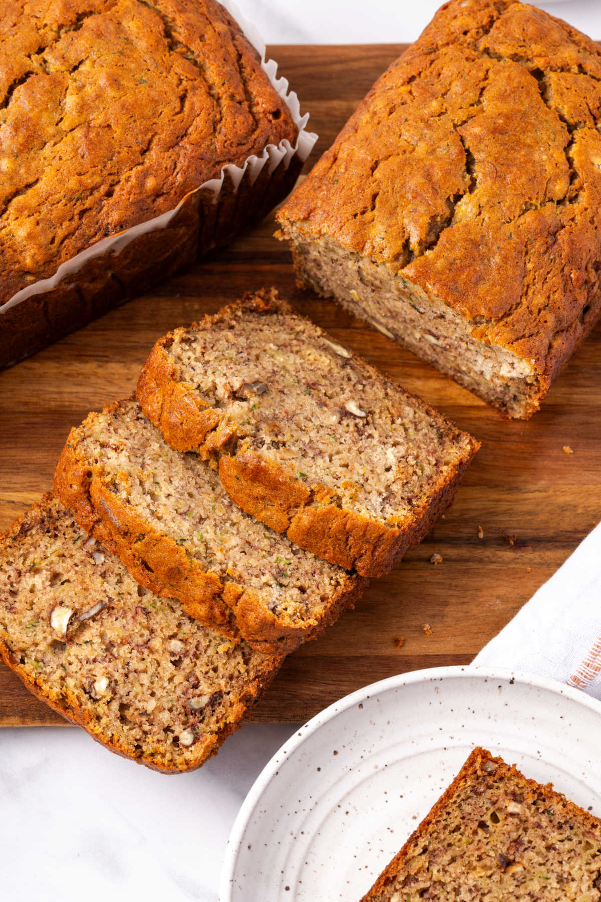 Sliced zucchini bread on wooden cutting board.