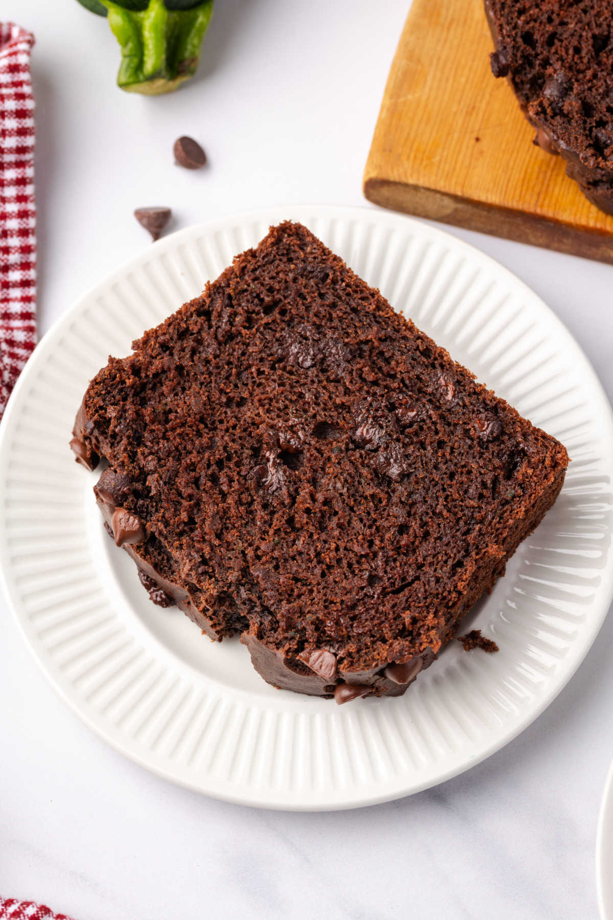 Slice of chocolate zucchini bread on small white plate.