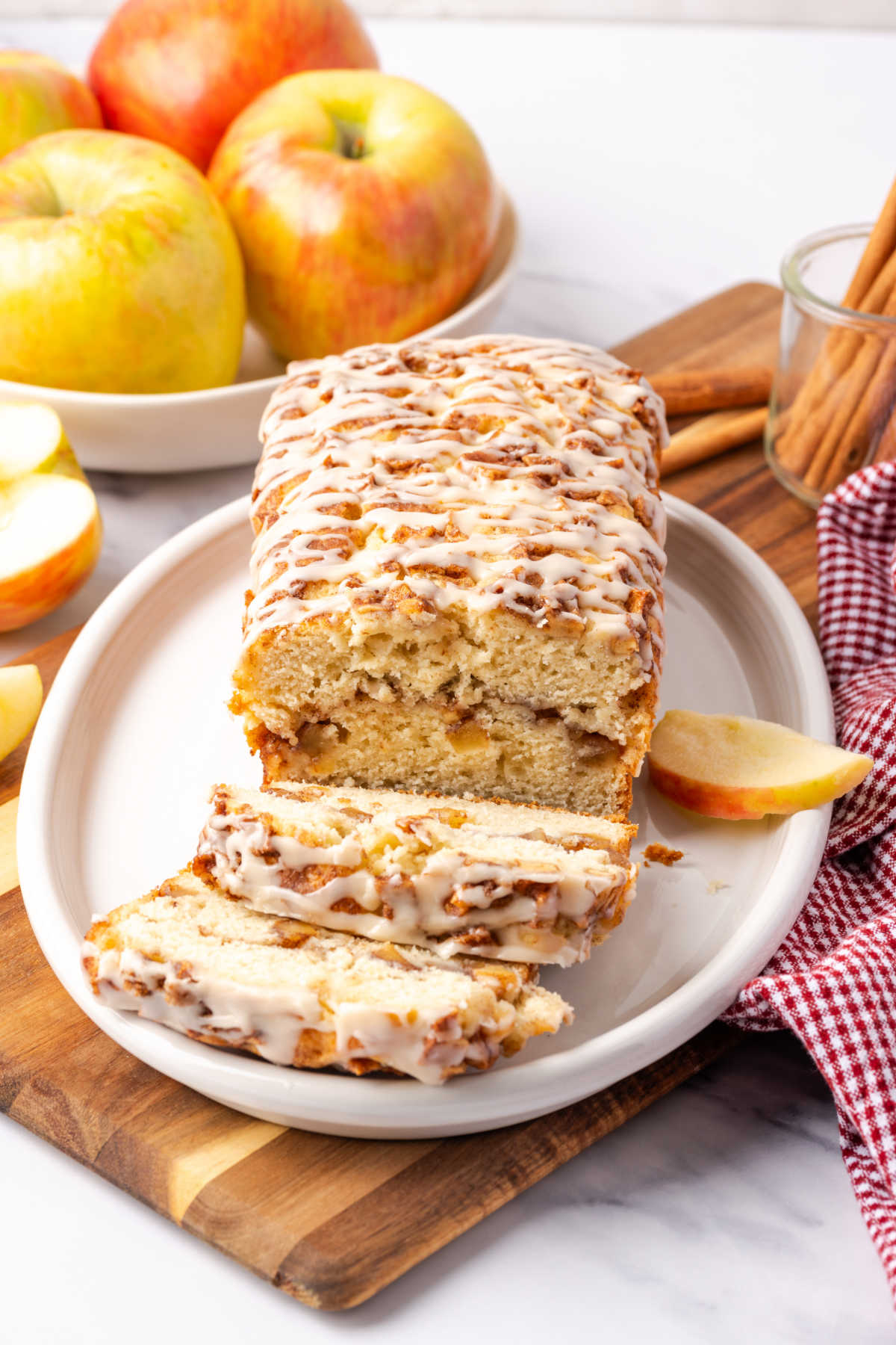 Apple loaf with icing on white oval plate.