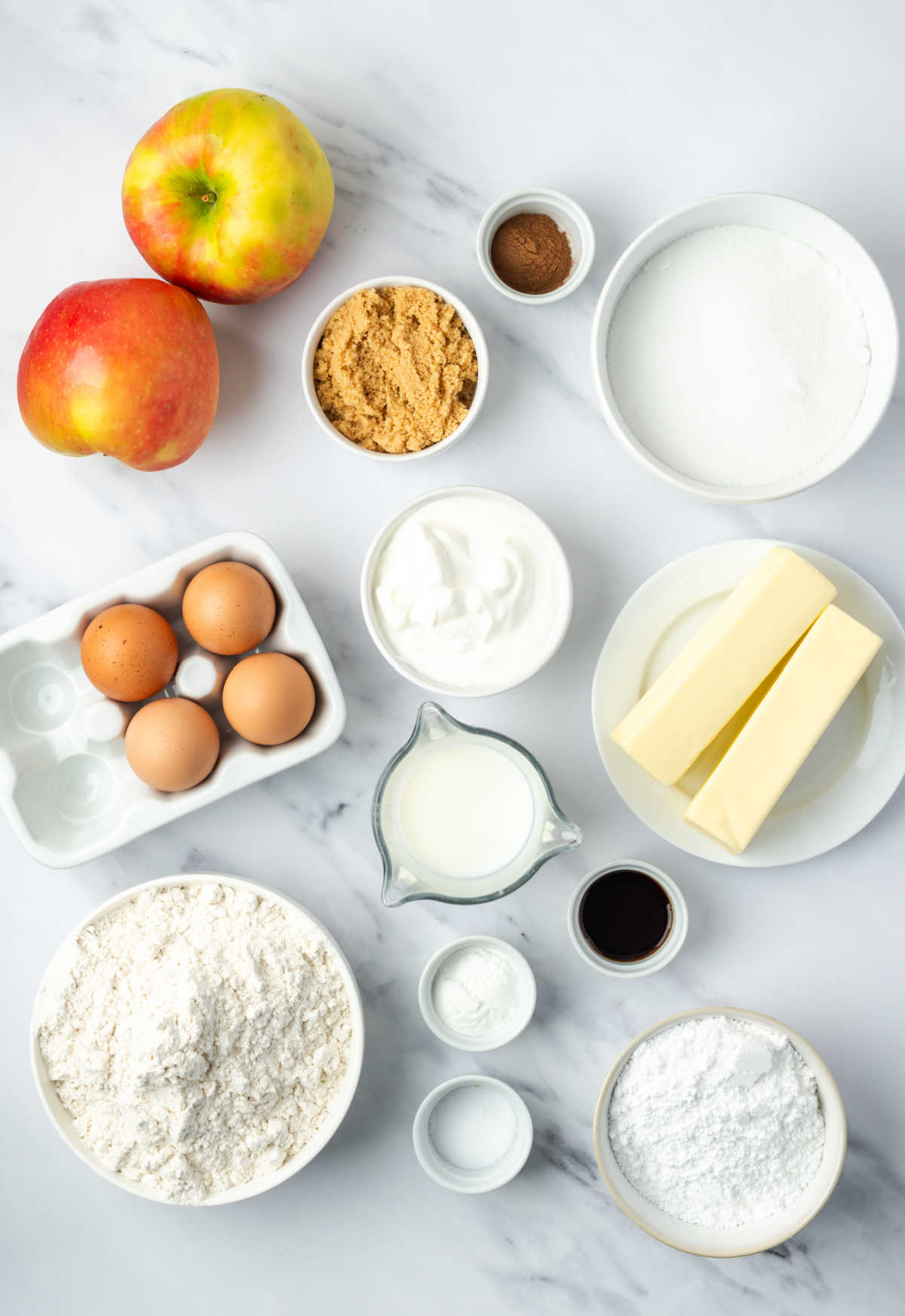 Ingredients in white bowls, apples to side.