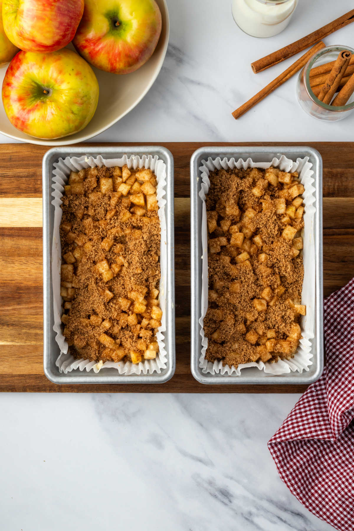 Step images metal loaf pans with cake batter, cinnamon apples.